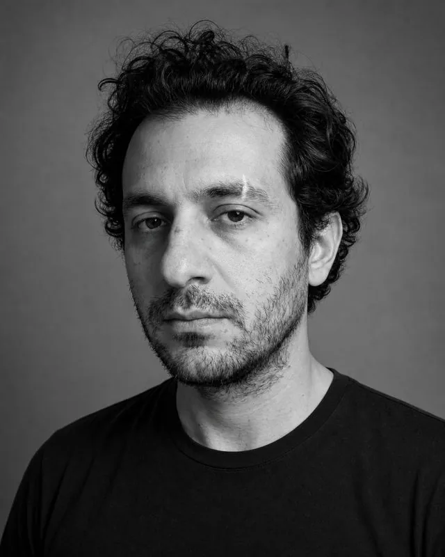 Black and white: a classic monochrome studio portrait with a large soft light and grey seamless behind, plain dark clothing