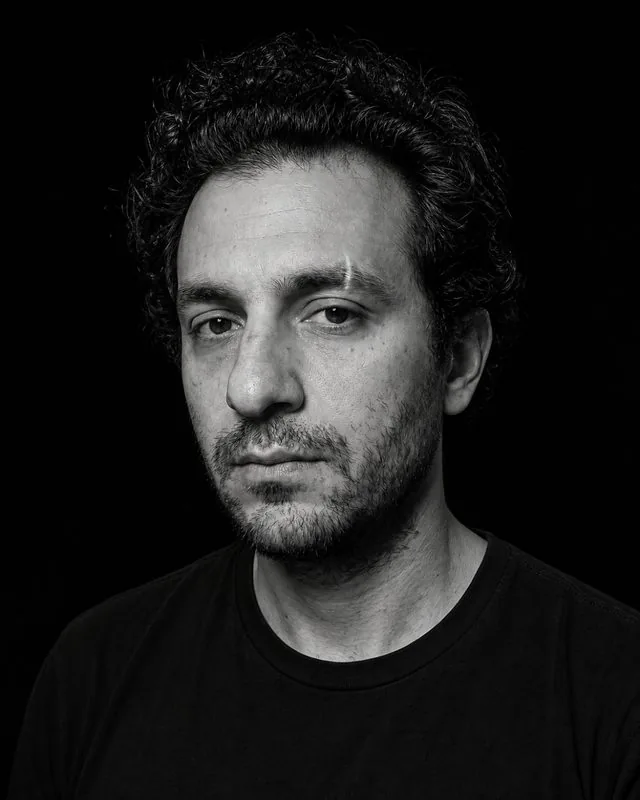 Black and white: a high-contrast monochrome frame in a black shirt, single hard light and pure black background