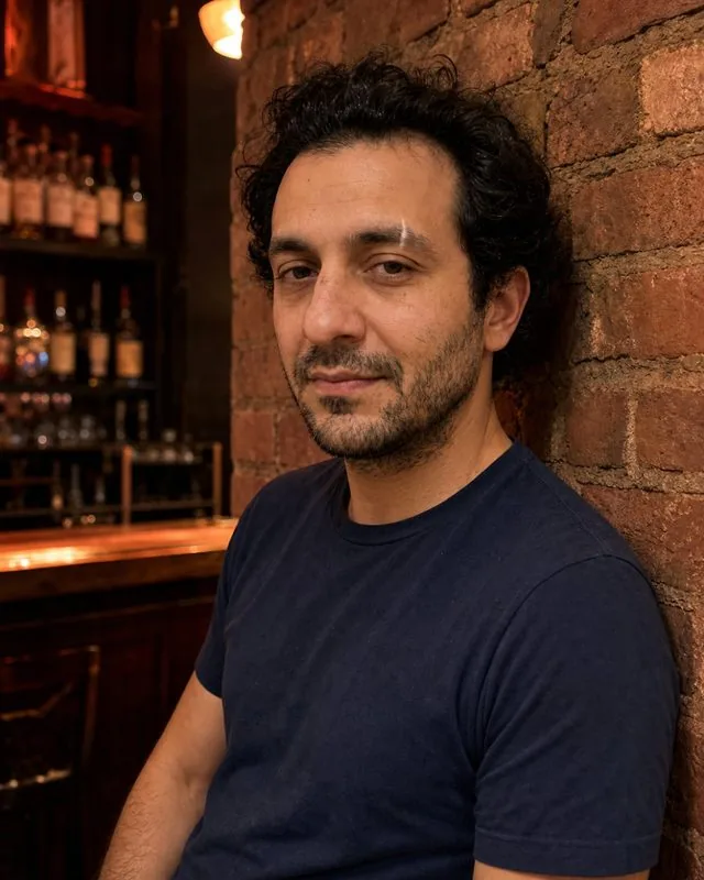 Live music: leaning against a brick wall near the bar, red and amber lighting, relaxed posture