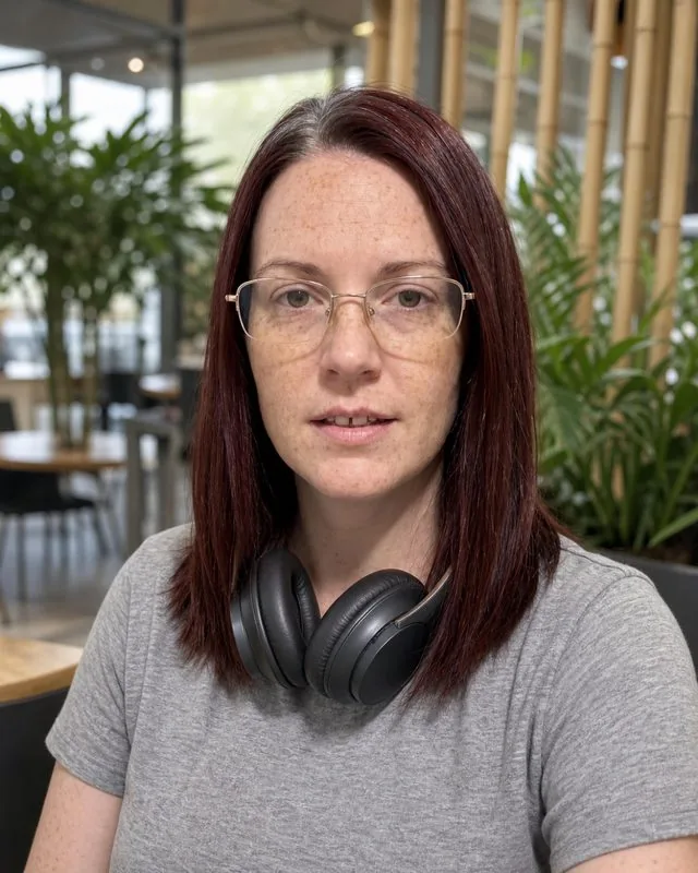 Digital nomad: in a co-working space with plants and bamboo, headphones around the neck, soft daylight