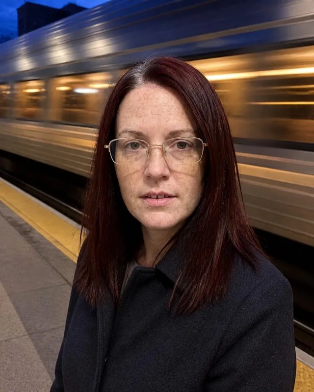 Long exposure: on a station platform as a train blurs through, sharp face and smeared carriage lights