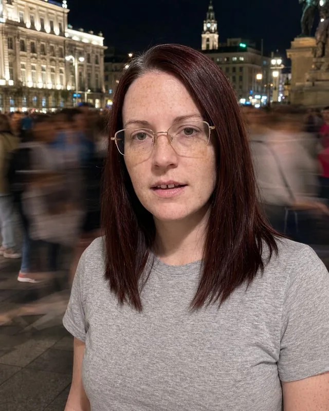 Long exposure: in a crowded square at night with people blurred into streaks, still and sharply lit