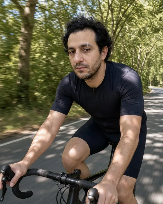 Cycling: riding through a tree-lined avenue with dappled light flickering across the kit