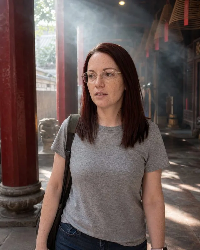 Spiritual: walking a temple corridor with incense smoke in the light shafts, quiet expression