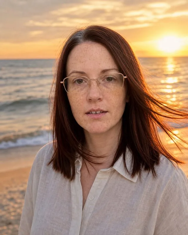 Beach sunset: standing on a beach at sunset in a light linen shirt, wind in the hair, warm rim light, ocean behind