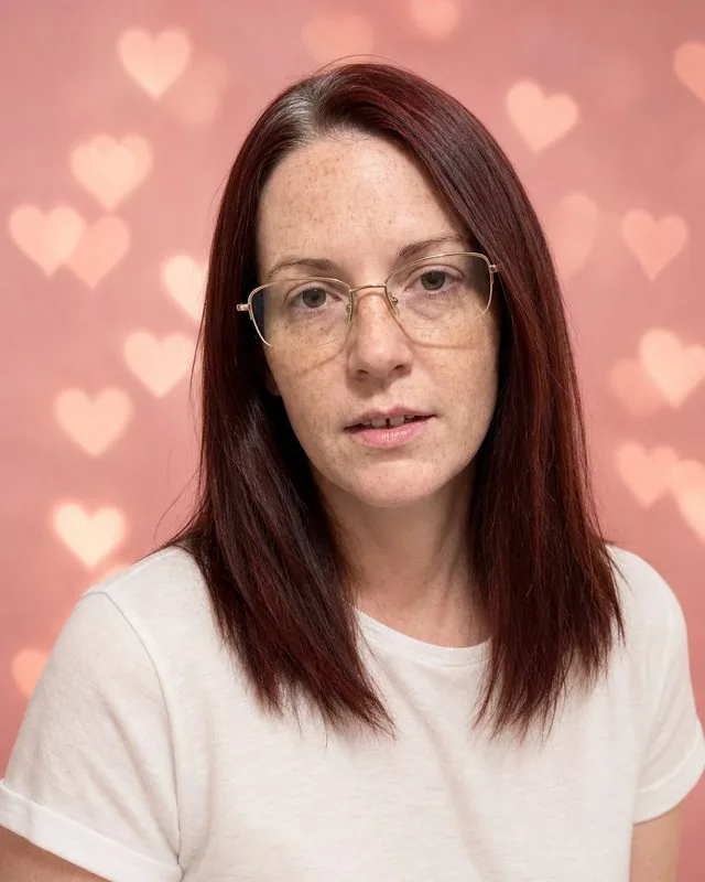 Valentine's: against a soft pink backdrop with heart-shaped bokeh behind, soft white shirt, gentle studio light