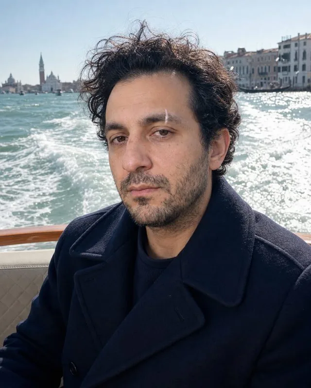 Venice: seated in a water taxi with the wake behind, navy peacoat, wind in the hair