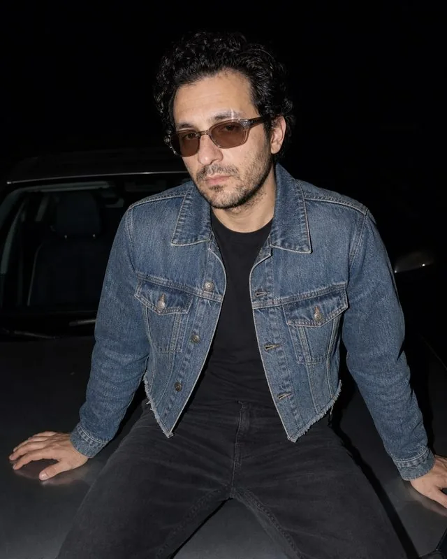 Y2K: sitting on a car bonnet at night in a cropped denim jacket, tinted sunglasses